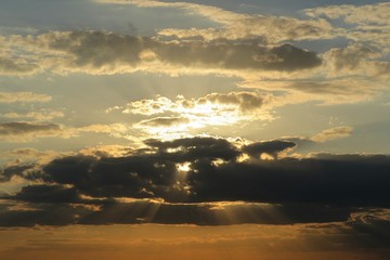 Beautiful golden sunset background with dark clouds