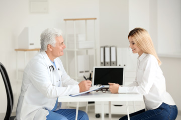 Fototapeta premium Male doctor consulting patient in clinic