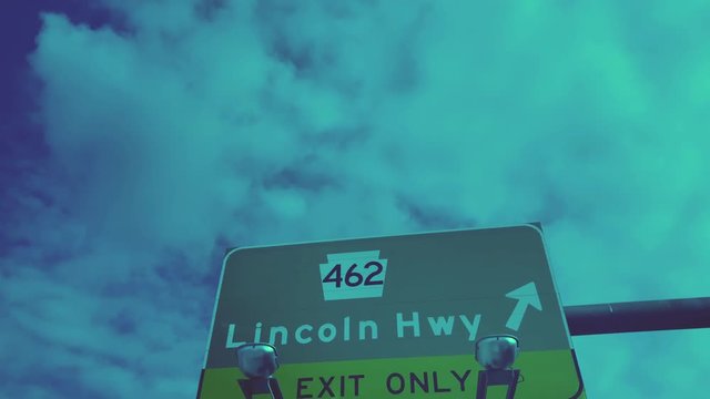 A low angle driver's view of passing under a Lincoln Highway PA Route 462 road sign.  	