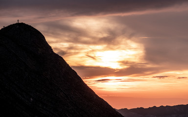 mountain peak with cross and people during sunset silhouette dramatic sunset brienzer rothorn switzerland
