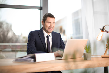 Young man in elegant suit at workplace