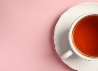 Cup of delicious tea with saucer on color background, top view