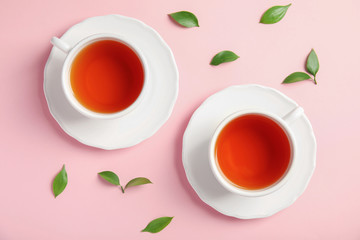 Flat lay composition with delicious tea and green leaves on color background