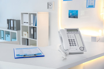 Telephone on reception desk in modern hospital