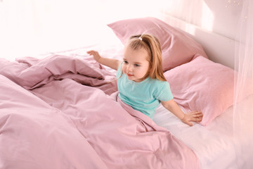 Cute little girl in bed at home