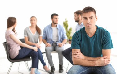 Sad young man at group therapy session