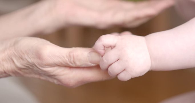 Baby hands touching senior hands
