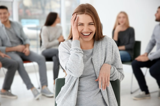 Laughing woman during group therapy, indoors