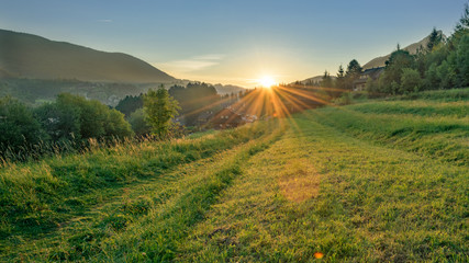 Landscape. Sunrise in a rural area of the town Terchova, Slovakia. Green summer season in a mountain resort.