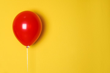 Red balloon on color background. Celebration time