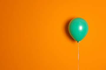 Green balloon on color background. Celebration time