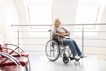 Mature woman sitting in wheelchair indoors