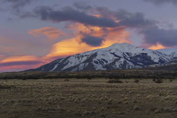 Scenic View Of Orange Sunset Against Snowcapped Mountain