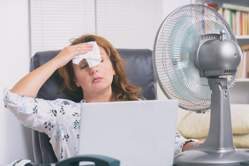 Woman suffers from heat in the office or at home