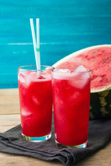Watermelon smoothies on a black napkin and blue wooden background, cocktail, cold drink