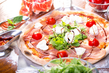 close up of delicious italian pizza with ham, mozzarella and tomatoes