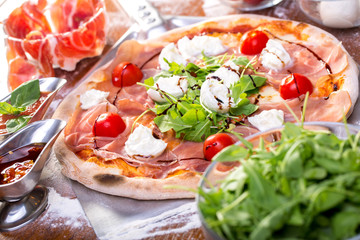 close up of delicious italian pizza with ham, mozzarella and tomatoes