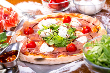 close up of delicious italian pizza with ham, mozzarella and tomatoes