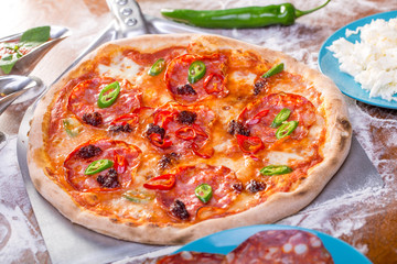 close up of tasty spicy pizza with salami and mozzarella