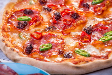 close up of tasty spicy pizza with salami and mozzarella