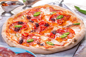 close up of tasty spicy pizza with salami and mozzarella