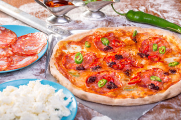 close up of tasty spicy pizza with salami and mozzarella