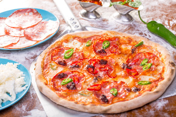 close up of tasty spicy pizza with salami and mozzarella