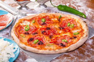 close up of tasty spicy pizza with salami and mozzarella