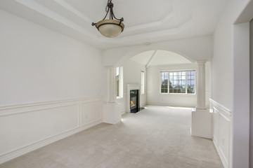 Empty formal dining room with white walls.