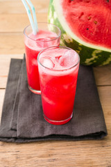 Watermelon smoothies on a black napkin and wooden background, cocktail, cold drink