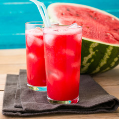 Watermelon smoothies on a black napkin and blue wooden background, cocktail, cold drink