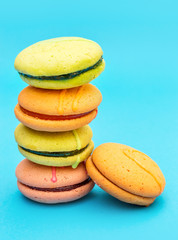 Stack of colorful macaroons on blue.