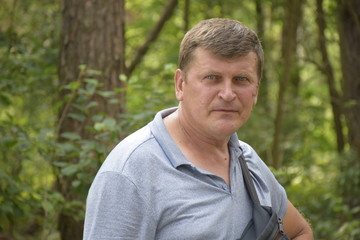 Naklejka na ściany i meble портрет серьезного кавказского мужчины в сосновом лесу 