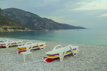 The bay is surrounded by mountains, on the yellow sand of the shelf, in the sea the ship.