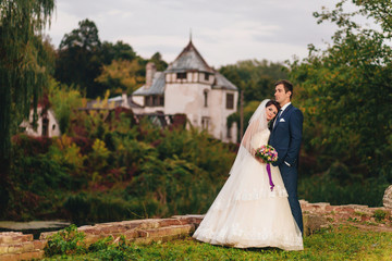 The bride and groom embrace against the background of the fortress tower