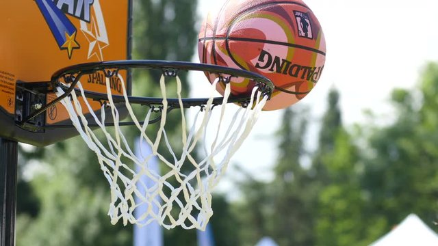 Children throw the ball into basketball hoop - active playing sport game kids
