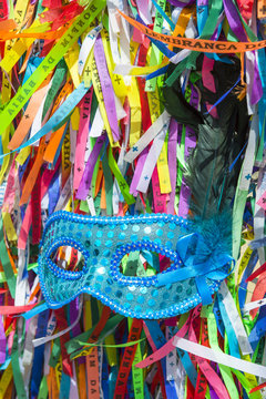 Blue sequined carnival mask in a background of Brazilian wish ribbons Salvador Bahia Brazil. 