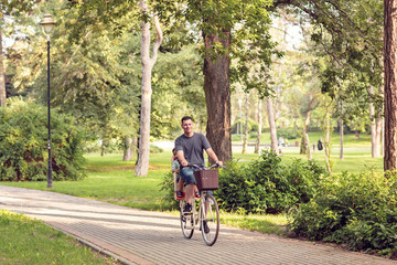 Naklejka premium Family cycling outdoors – Father and son riding bike in the park.