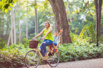 Happy family. Family sport and healthy lifestyle- mother and son riding a bicycle together outdoors...