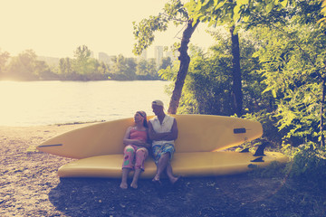 Happy couple of sup surfers is relaxing in a river camping