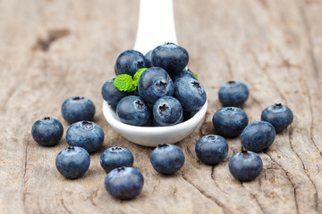 Blueberries in white spoon on wooden table, Healthy eating and nutrition concept