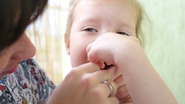 Oral hygiene of the child - mother brushing teeth to little daughter - portrait