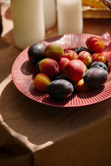 organic plums on plate on table in garden