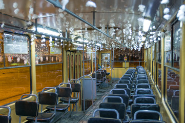 Празднично украшенный трамвай в новогоднюю ночь, салон и пустые кресла пассажиров - obrazy, fototapety, plakaty