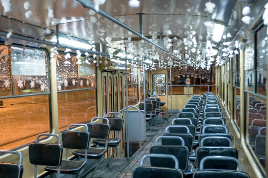 Празднично украшенный трамвай в новогоднюю ночь, салон и пустые кресла пассажиров