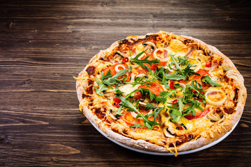 Pizza with ham and vegetables on wooden table 