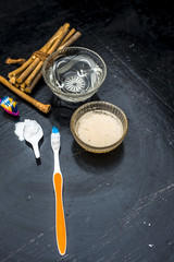 Close up of best and trusted home remedy for Tooth problems and yellow teeth i.e. baking soda with water and normal tooth brush it daily thrice.All ingredients on wooden surface with neem bark.