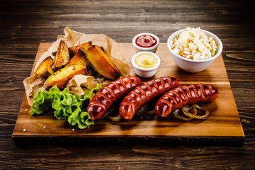 Grilled sausages, baked potatoes and vegetables 