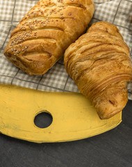 freshly baked croissants on wooden cutting board, top view