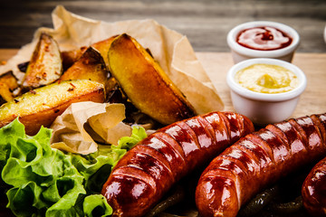 Grilled sausages, baked potatoes and vegetables 